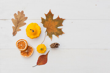 Autumn holiday frame composition with pattern made of leaf, punpkins, dried orange, pine cone on...