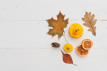 Autumn holiday frame composition with pattern made of leaf, punpkins, dried orange, pine cone on...