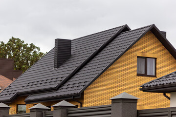 The roof and chimney are made of black metal tiles. Plastic water bend. The concept of increasing the attic