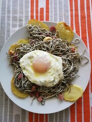  gulas with potatoes, fried egg, and ham, topped with garlic and dried chili peppers