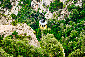 Montserrat Aerial Cableway, a yellow funicular that goes up with passengers to the Montserrat Mountain and the Monastery, Barcelona, ​​Catalonia