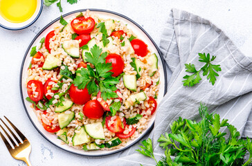 Middle Eastern salad with bulgur, tomatoes, cucumbers and parsley.. White background, top view