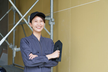 石膏ボードにコテで塗る女性職人