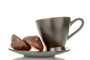 Marshmallow in chocolate on ceramic saucer with cup, macro, isolated on white background.