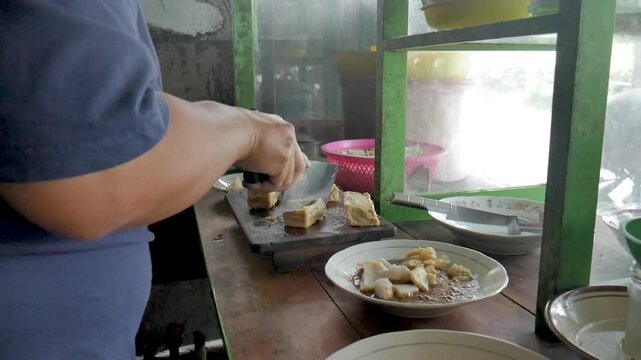 The process of making kupat tahu. Typical Indonesian food. Traders preparing food orders.