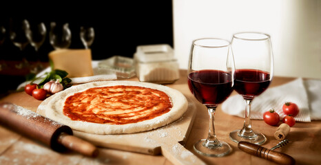 Preparação de pizza artesanal com 
dois copos de vinho tinto em ambiente acolhedor