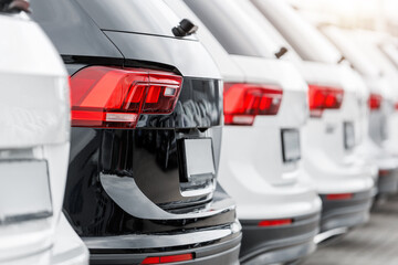 Back view many modern new SUV cars fleet stock at dealership parking lot. Automobile market...