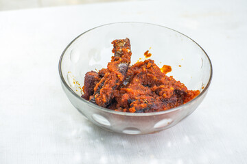 Spicy Smoked Fish Sambal in a clear bowl on a white table, commonly called Manyung, a spicy food that stimulates the appetite, eaten with white rice