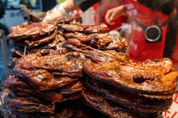 Authentic Street Food: Glazed Savory Meats at a Vibrant Market Stall