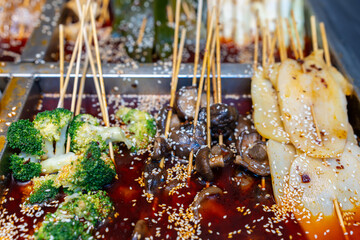 Colorful Assorted Vegetable Skewers in Spicy Sauce with Sesame Seeds