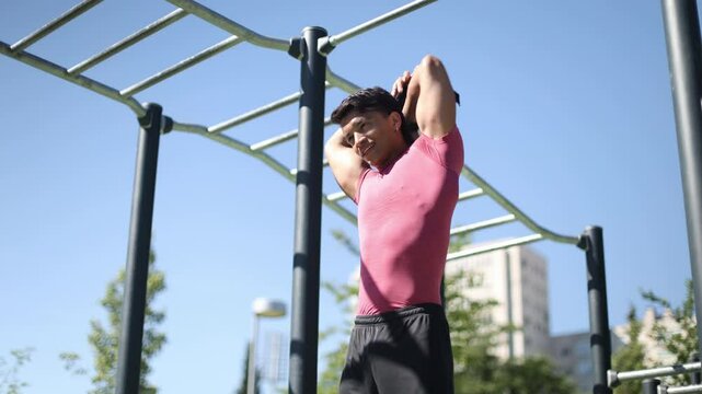 Young athlete stretching triceps at outdoor gym