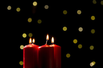 Four red candles burning and extinguishing on a festive background, close up shot. Candlelight, Advent celebration, remembrance, and religion concepts.
