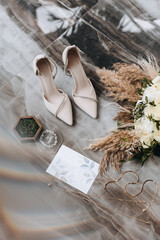 Luxury details of wedding accessories. Arrangement on the floor of marble bouquet, invitations,...