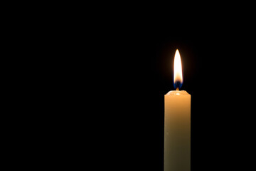 White thin candle on a black background, close up shot. Grief, loss, and mourning concepts.
