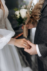 Close-up photo of the men`s holding woman hand with golden wedding ring with diamond. Wedding ring before the proposal. Luxury wedding rings