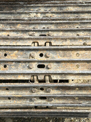 Close-up view of rugged, heavy-duty crawler tracks on construction machinery. The tracks are covere