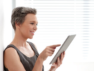 Fototapeta premium Smile, tablet and mature business woman research, reading email or check update for ads in startup. Technology, happy manager and creative brand strategist work on design, campaign review or feedback