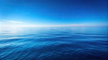 A vast expanse of calm ocean waters reflecting a clear blue sky with only a few wispy clouds scattered across the horizon, ocean views, natural beauty, calm water, peaceful atmosphere