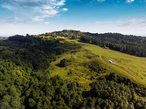 Sunlit Green Hills and Meadow Slopes Under Bright Blue Sky