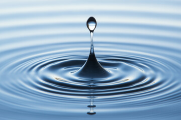 A single water droplet creates mesmerizing ripples on a serene blue surface at dawn. Generative AI