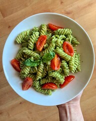 pesto pasta topped with fresh tomatoes and basil