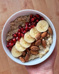 porridge topped with pomegranate seeds, banana and almonds
