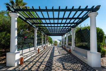 Way with pergola to Dome in Kalithea (Rhodes, Greece) - Text translation: "Reps sneaking through the rocks"