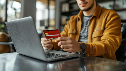 During Black Friday, a shopper browses online deals on a laptop while holding a credit card in a modern café setting