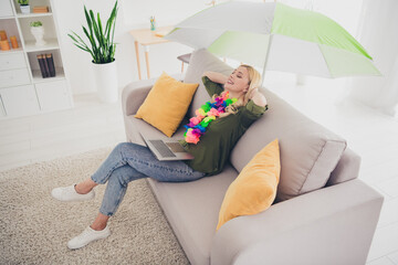 Photo of pretty adorable woman sit sofa hold arms behind head dream summer vacation relax rest...