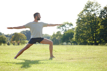 Nature, man and stretching at park with yoga for exercise, balance and mobility on grass. Pilates, mature yogi and warrior pose on lawn for workout, holistic wellness and posture with fitness outdoor