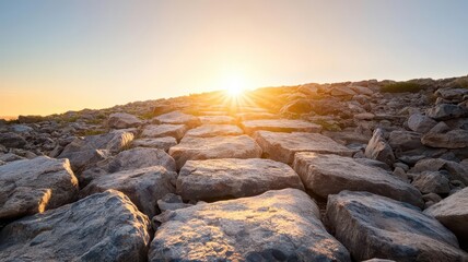 Obraz premium A rocky trail illuminated by the rising sun, guiding the way through a natural landscape