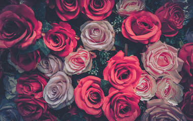 A vintage aesthetic image of a cluster of red, pink, and white roses with green foliage.