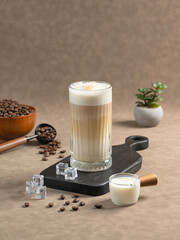 Iced Cappuccino: A tall glass of Iced Cappuccino with frothy milk, served with ice cubes, coffee beans, and a small milk jug. A coffee grinder and beans complete the scene.