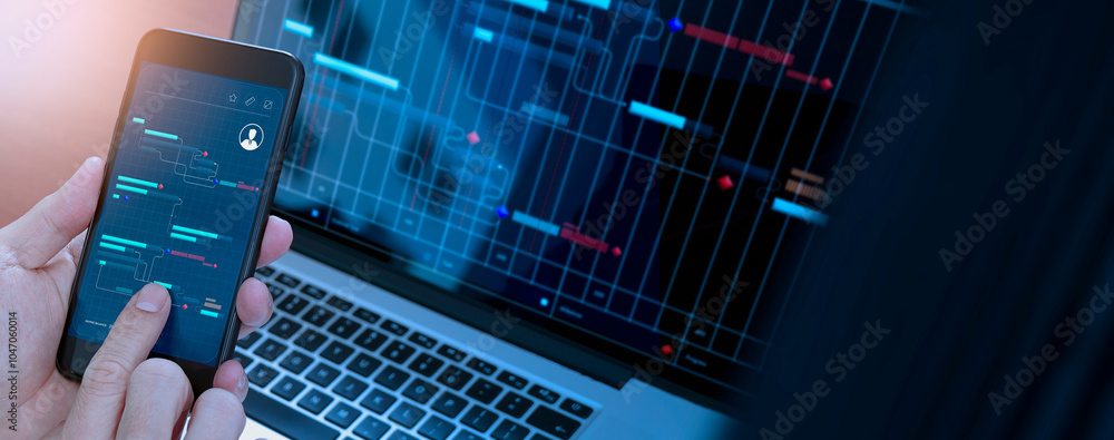 Poster a close-up of a hand holding a smartphone displaying a data management interface, with a laptop scre