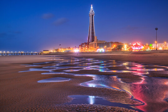 Beautiful landscape of Blackpool beach with city lights and tower at dusk. United Kingdom