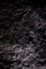 Extreme close up of painted in black handmade paper clay with a structure and rough texture. Paper recycling. Selective focus, shallow depth of field.