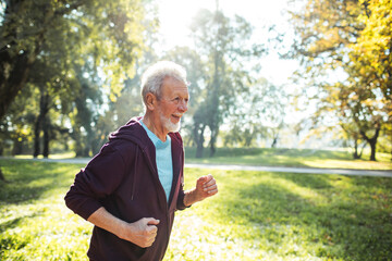 Smiling senior man jogging in the park