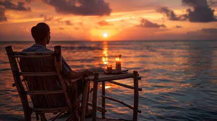 Obraz premium Man Relaxing in a Chair on a Dock Overlooking a Sunset