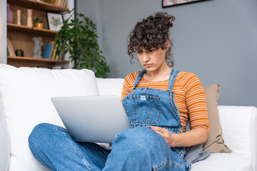 Young woman or girl looking at laptop computer screen with eyes wide open, cant believe that her...