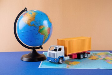 Global trade symbolized by toy truck on world map.