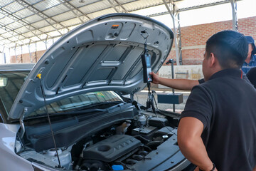 Men working on vehicle inspection with mechatronic equipment