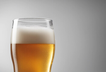 Glass of cold beer with foam bubbles in drink isolated on white background