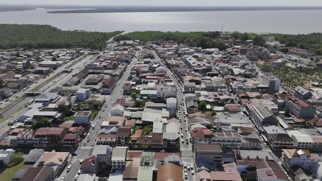 Drone flies west over historic city center toward Cayenne River in Cayenne, French Guiana, France