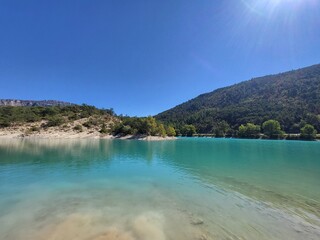 Turquoise Lake with Mountain Backdrop under Clear Blue Sky in Europe