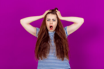 Shocked Young Woman Gripping Her Head and Pulling Hair in Distress and Disbelief. Shock, Surprise,...