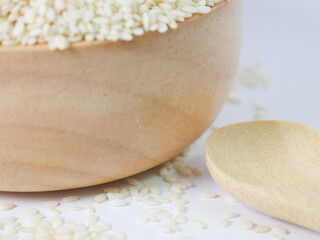 sesame in a wooden bowl and wooden spoon