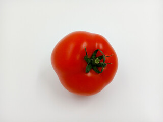 Red tomato with green branches and leaves. The vegetable from the farm. A fresh juicy product. Sauces, ketchup are made from it. Culinary theme, catalog, food packaging for a supermarket or blog.