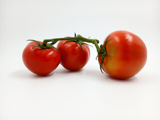 Red tomato with green branches and leaves. The vegetable from the farm. A fresh juicy product. Sauces, ketchup are made from it. Culinary theme, catalog, food packaging for a supermarket or blog.