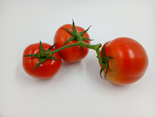 Red tomato with green branches and leaves. The vegetable from the farm. A fresh juicy product. Sauces, ketchup are made from it. Culinary theme, catalog, food packaging for a supermarket or blog.