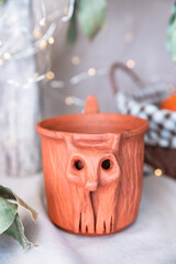 Rustic Clay Cup with Carved Forest Goblin Face, Evoking Folk Legends and Mystical Forest Spirits....